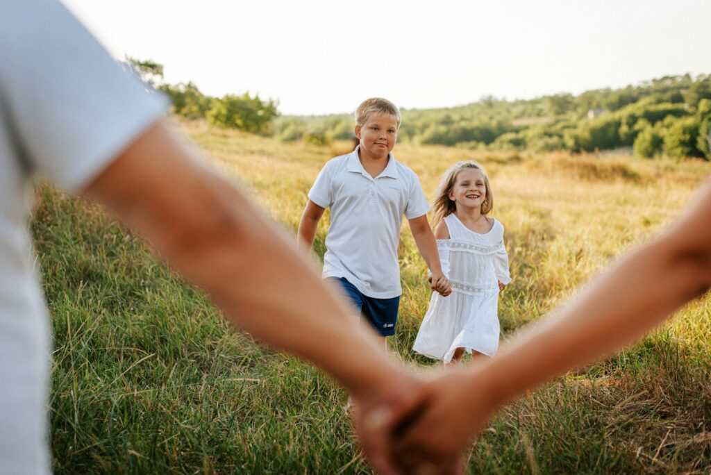 A couple of people holding hands in a field