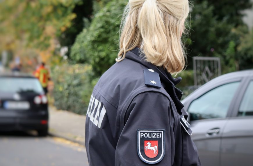 a woman in a police uniform standing on the side of the road
