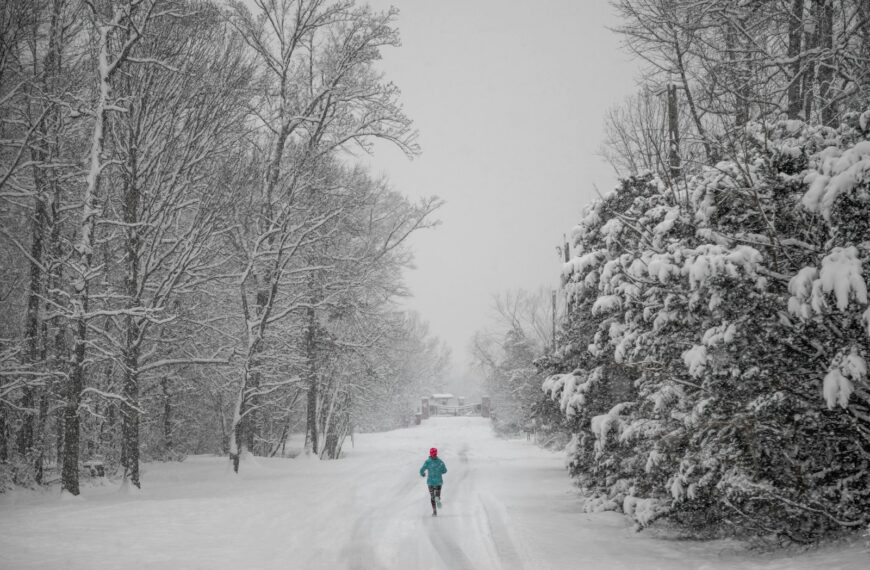 person jogging on snow capped pathway