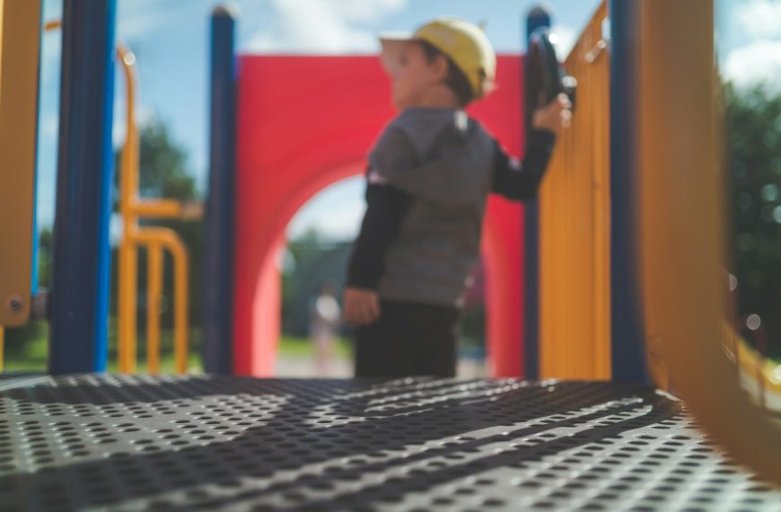 man in black vest and black pants standing beside red and yellow wall