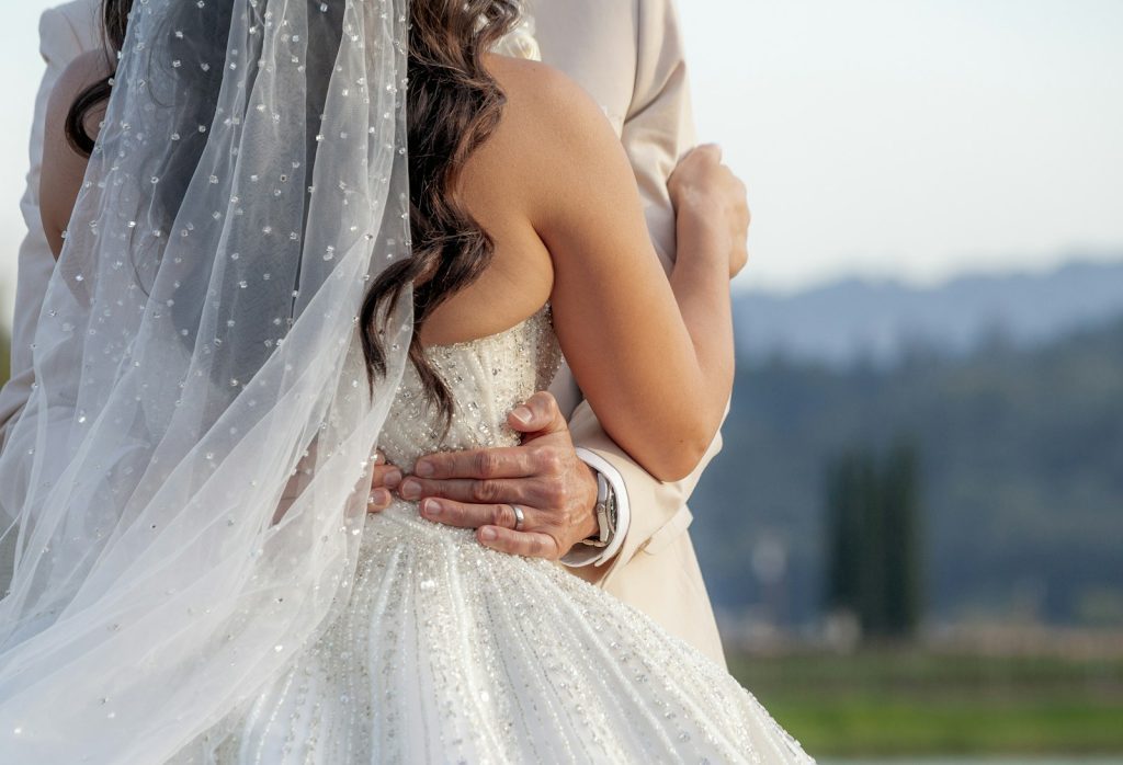 a bride and groom embracing each other under a veil