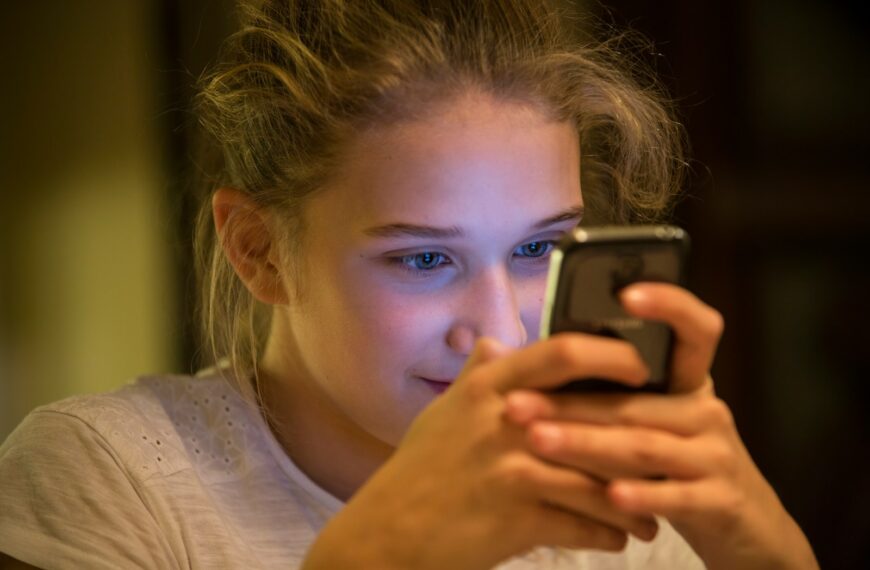 woman in gray top using smartphone