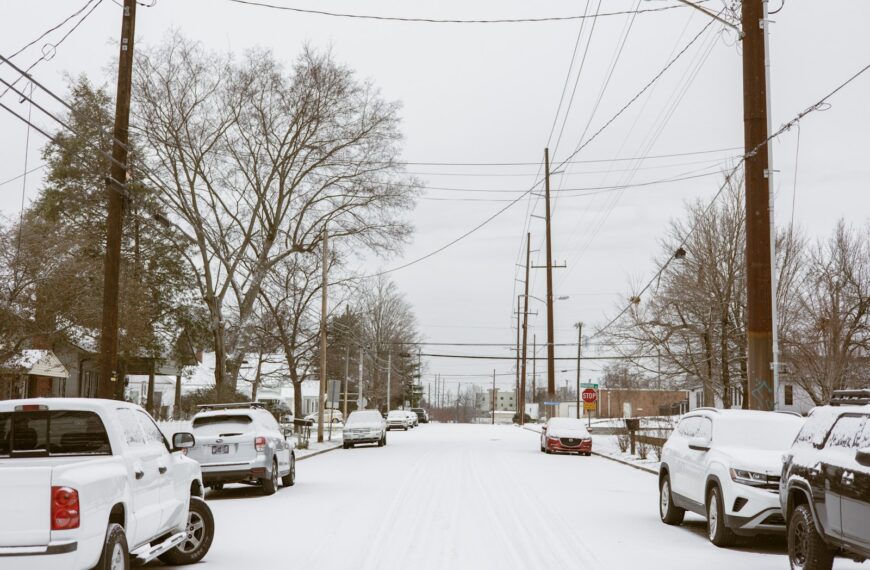 a snowy street filled with lots of cars