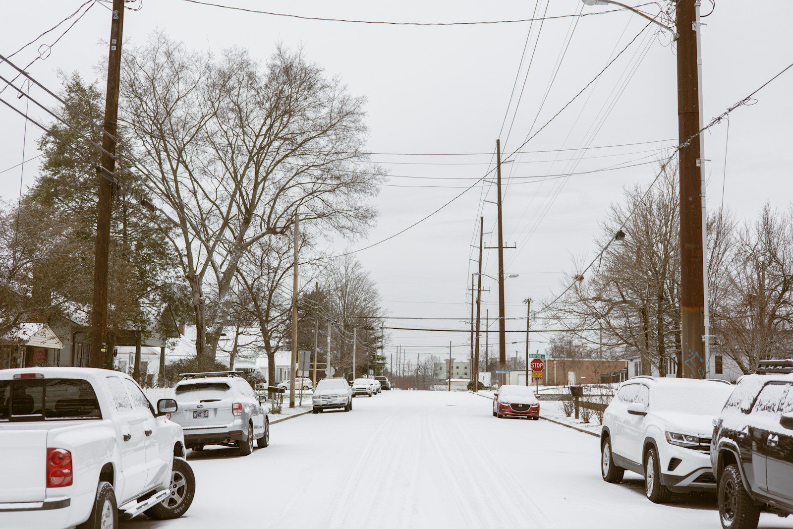 a snowy street filled with lots of cars