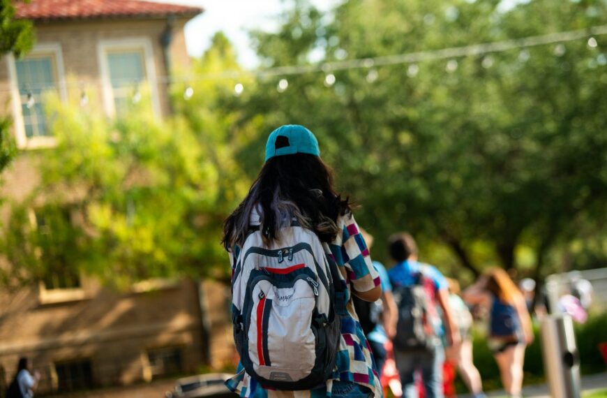 A student walks on campus with a backpack.