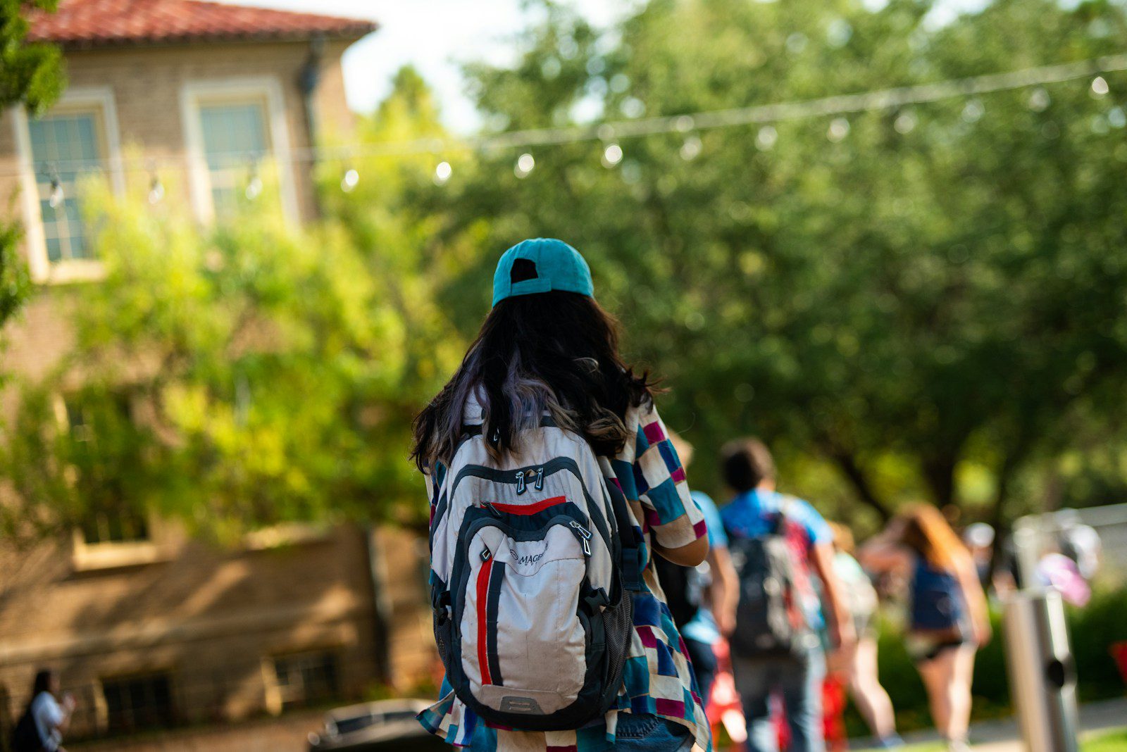 A student walks on campus with a backpack.