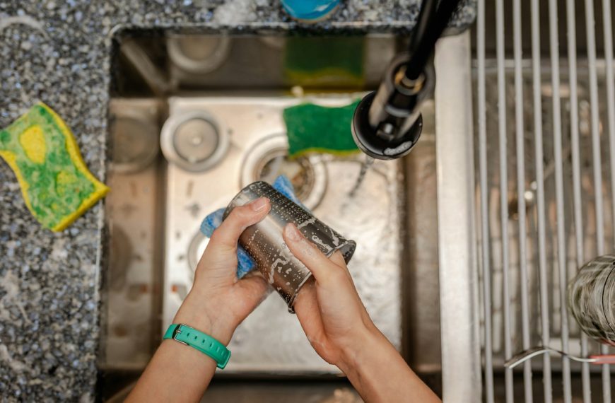 A person is cleaning a sink with a rag
