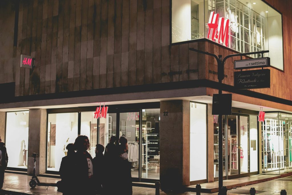 a group of people standing outside of a store at night