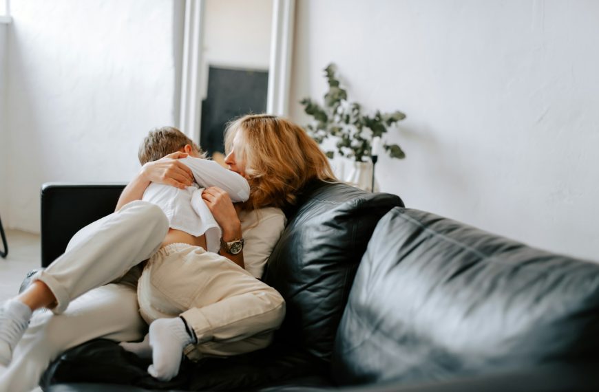 a woman sitting on a couch holding a baby
