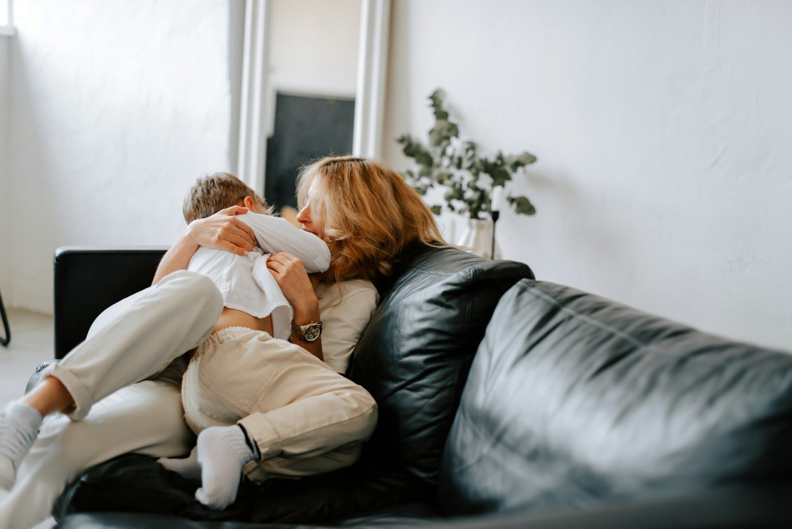 a woman sitting on a couch holding a baby