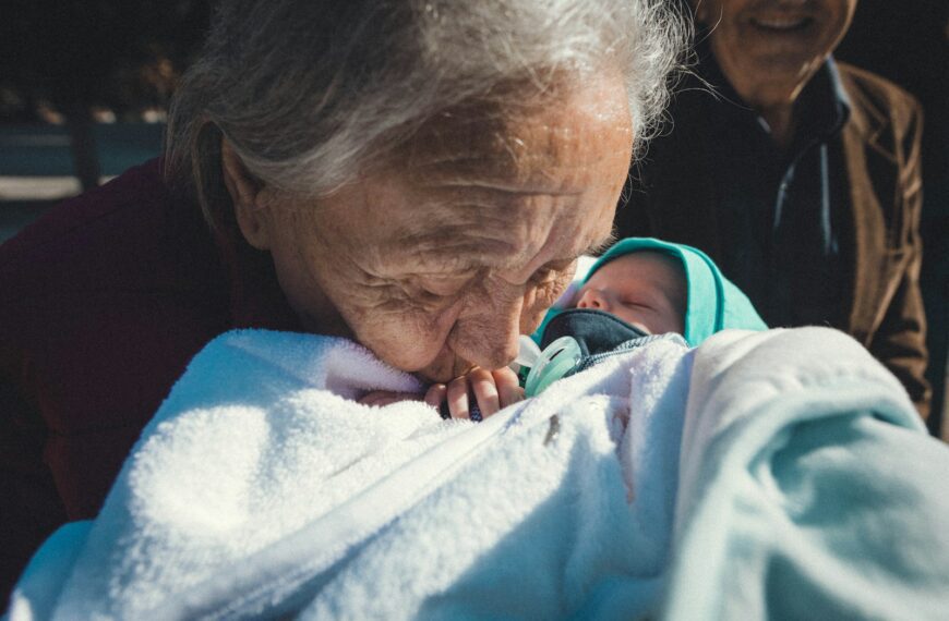 a woman holding a baby wrapped in a blanket