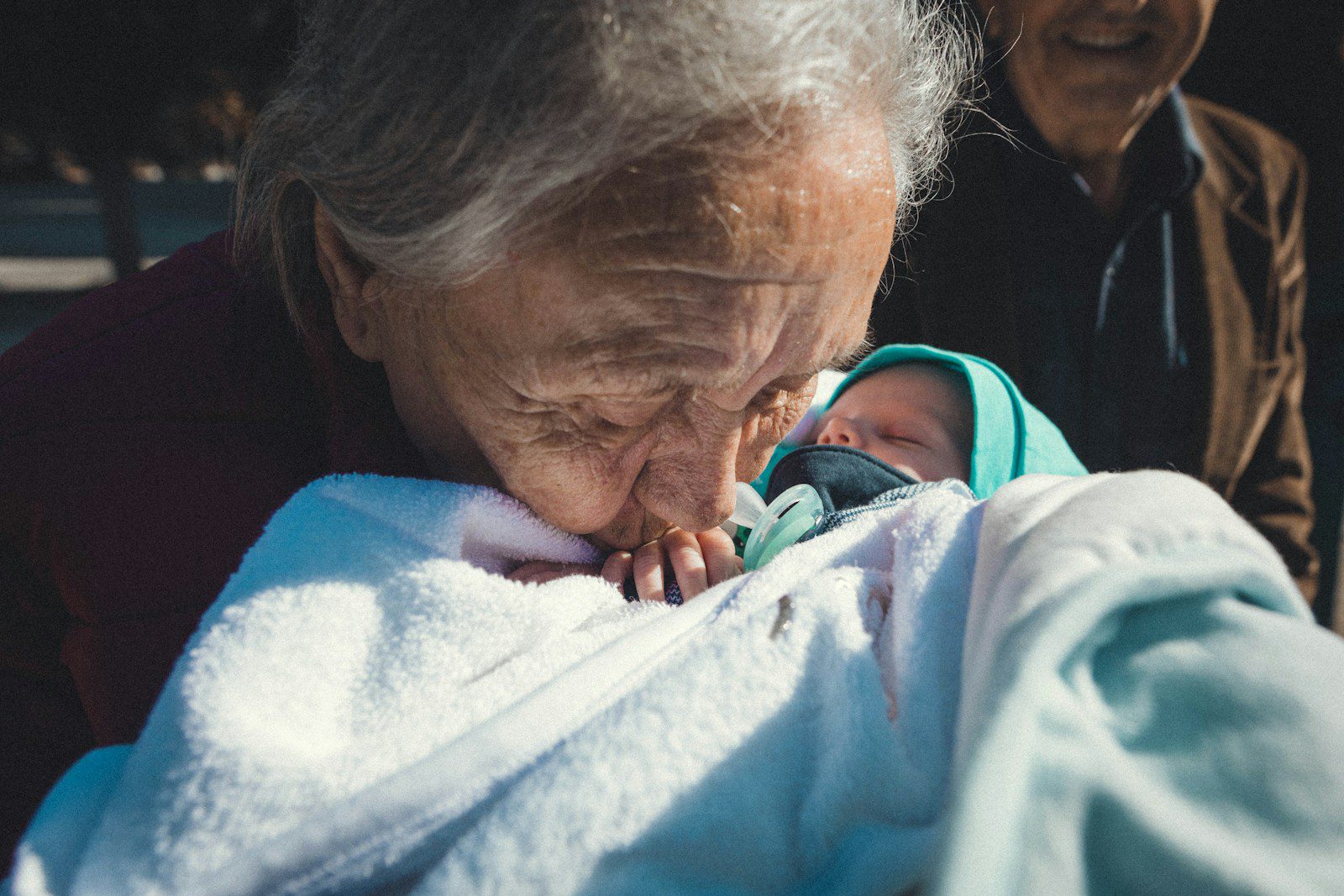 a woman holding a baby wrapped in a blanket