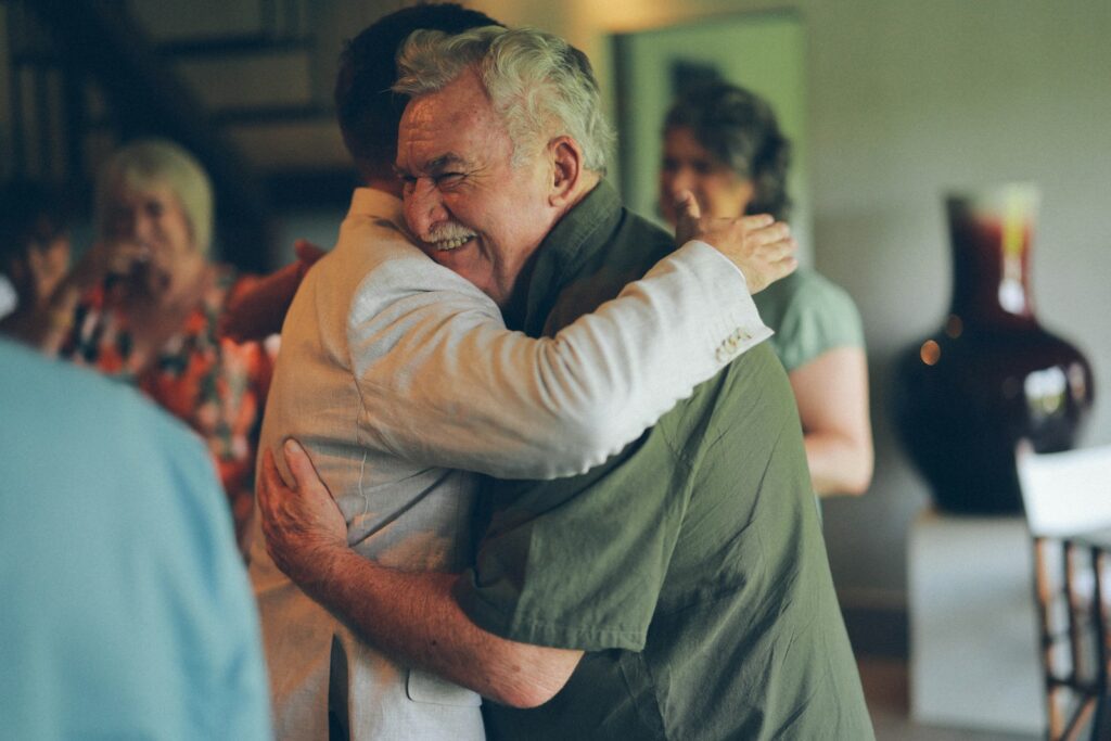 Two men hugging warmly at a gathering