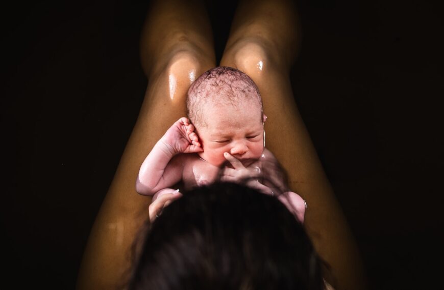 A woman holding a baby up in the air