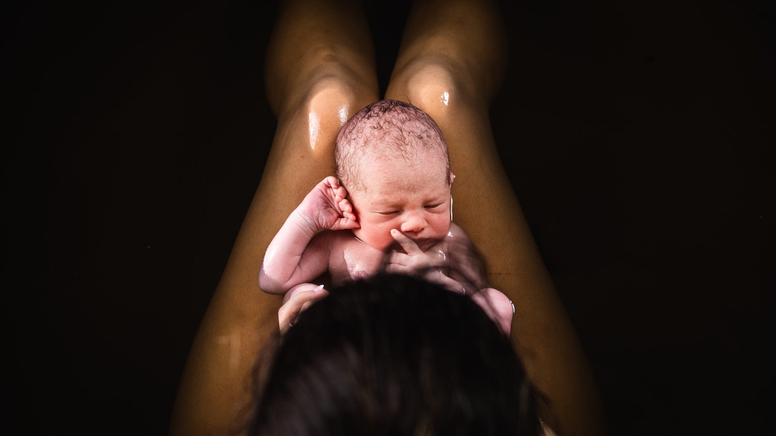 A woman holding a baby up in the air