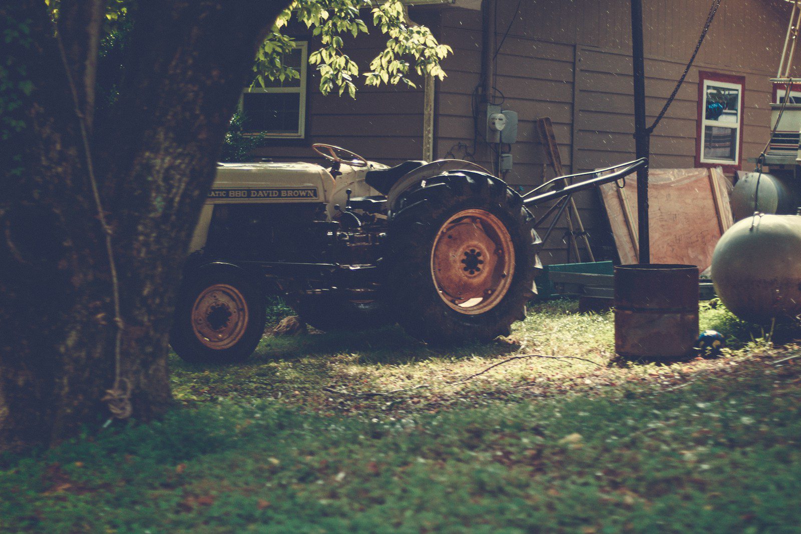 a lawn mower sitting in the grass next to a tree