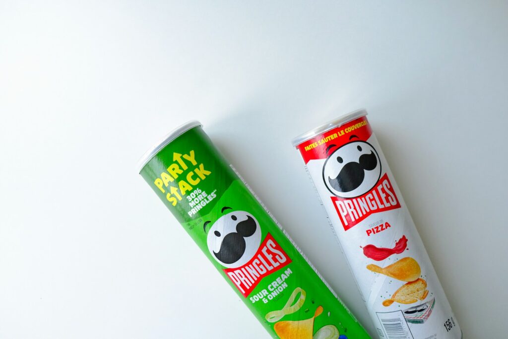 a tube of pringles next to a tube of chips