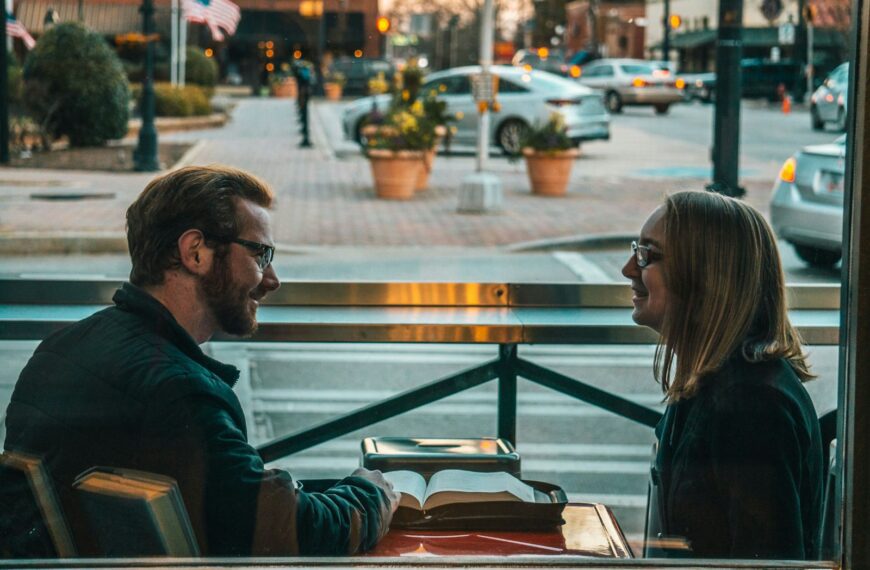 man and woman sitting while talking during daytime