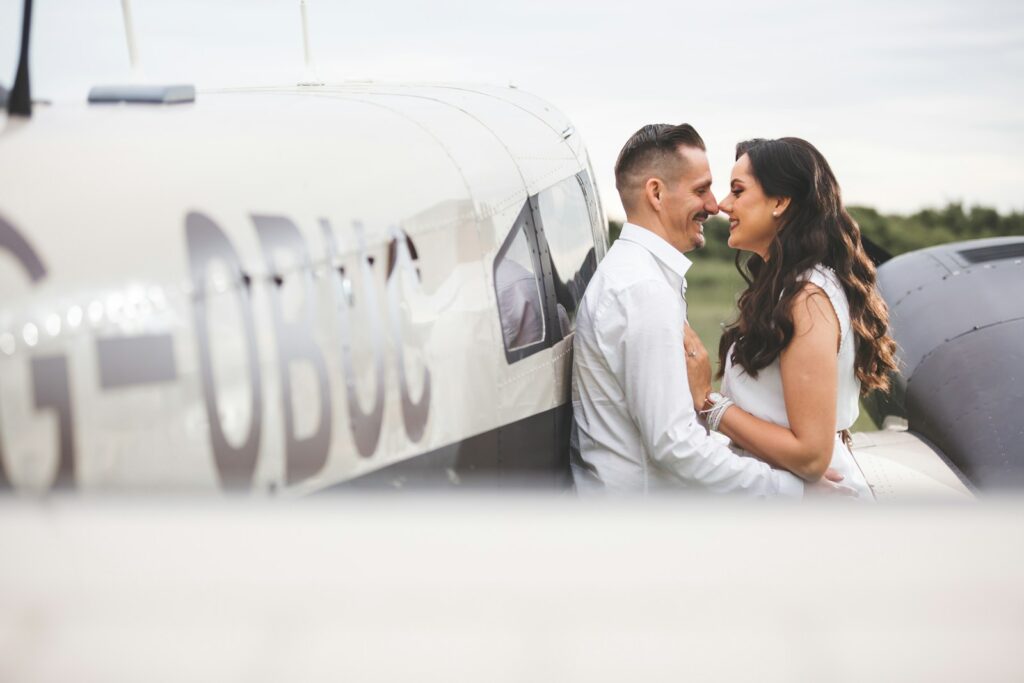 Couple embracing by a small airplane