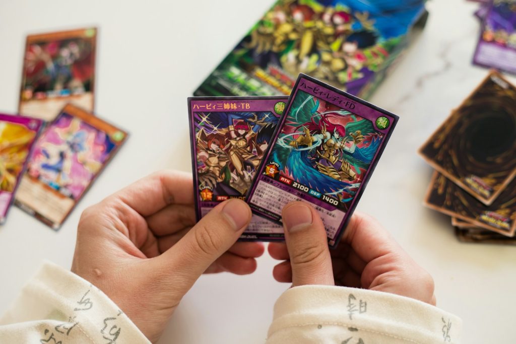 Hands are holding up two yu-gi-oh! cards.