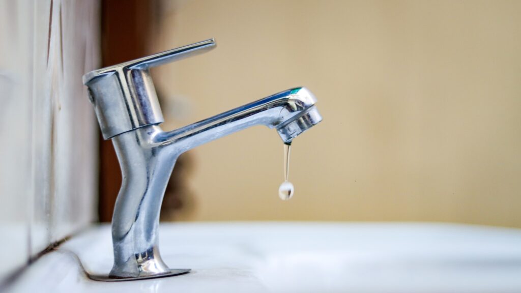 a faucet with a drop of water coming out of it