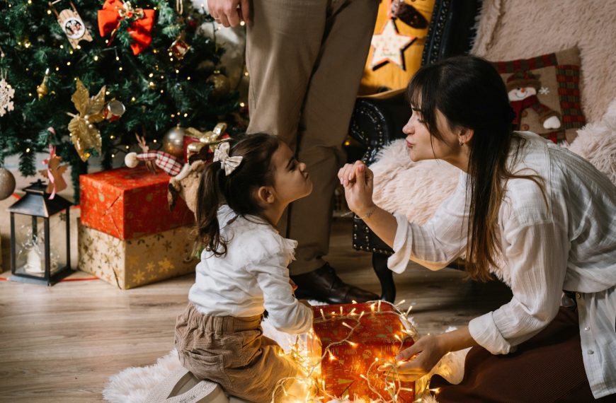 A woman kneeling down next to a little girl