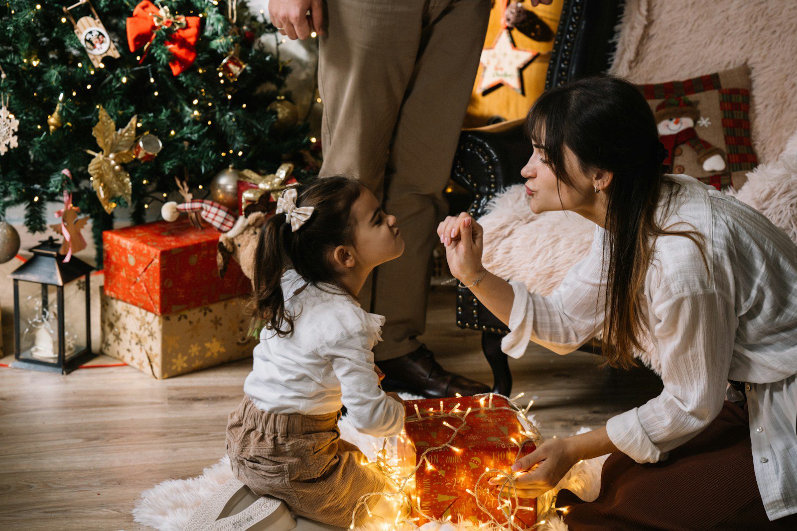 A woman kneeling down next to a little girl