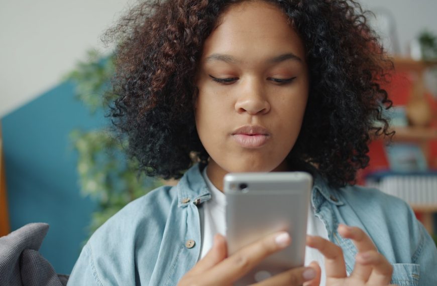 Young woman looking at smartphone screen of smartphone.