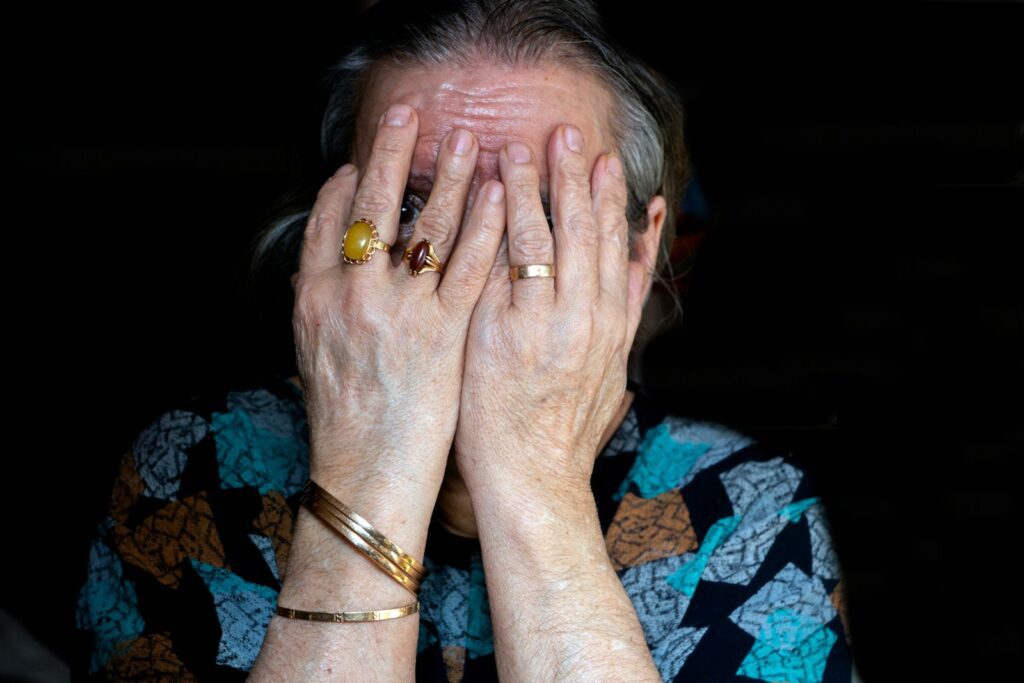 a woman covering her face with her hands