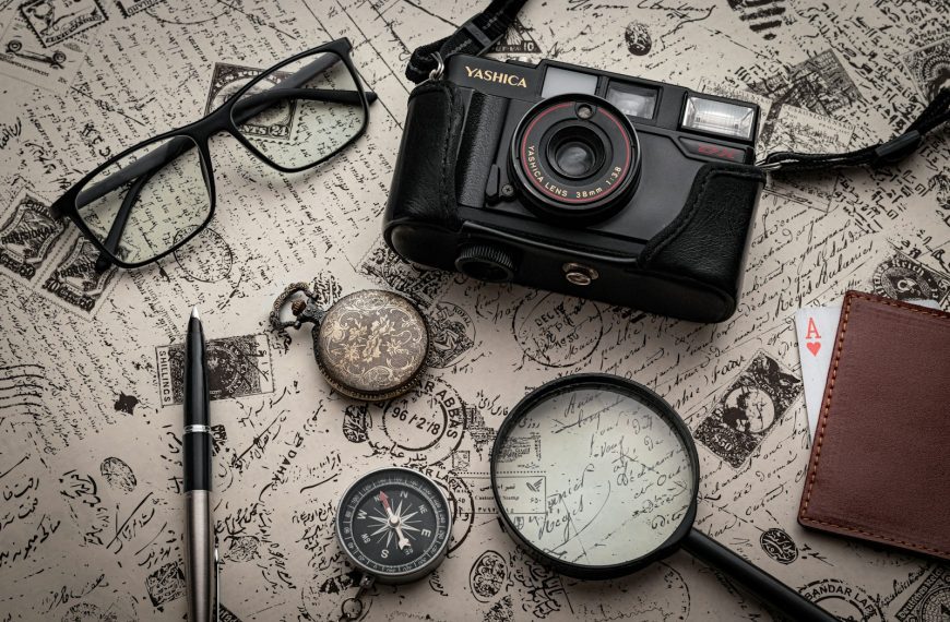 black nikon dslr camera beside black framed eyeglasses and black framed eyeglasses