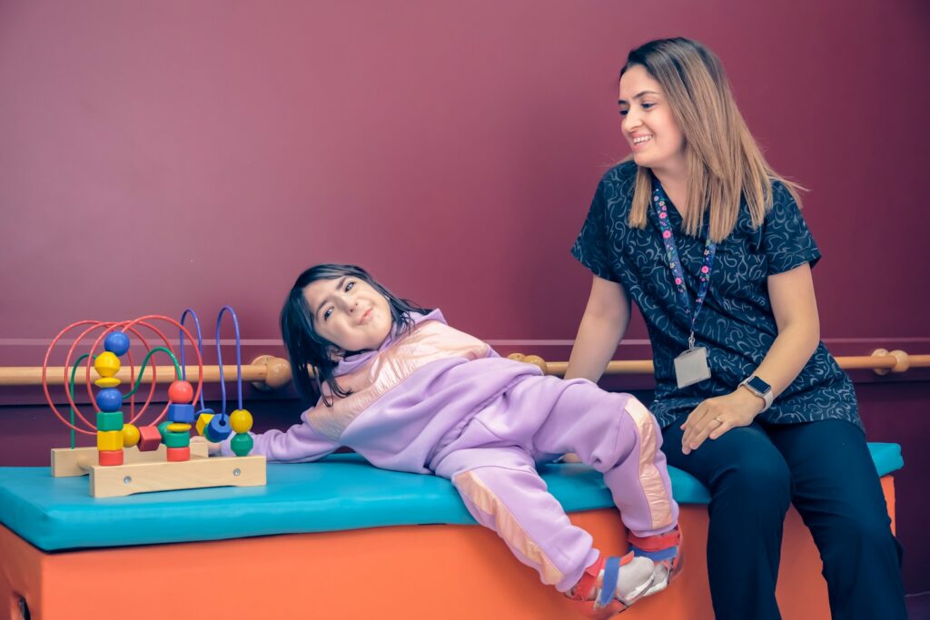 a woman sitting next to a little girl on a bench