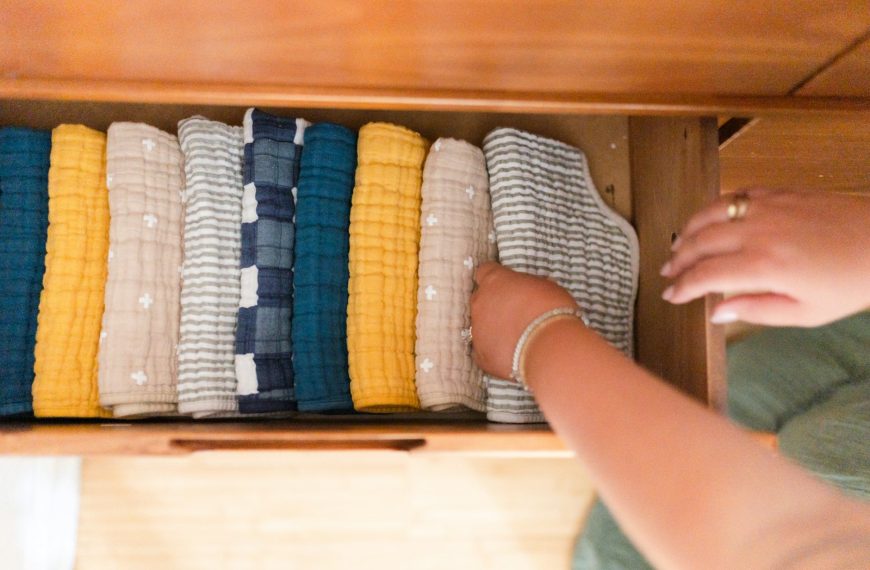 a woman is looking at a drawer full of sweaters