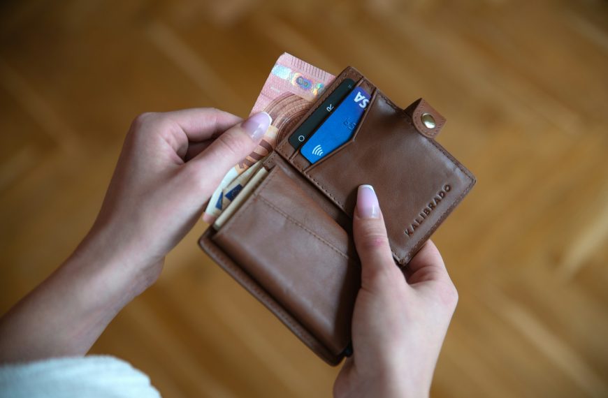 person holding brown leather card wallet