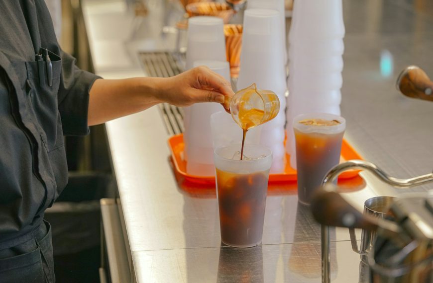 a person pouring a drink into a glass