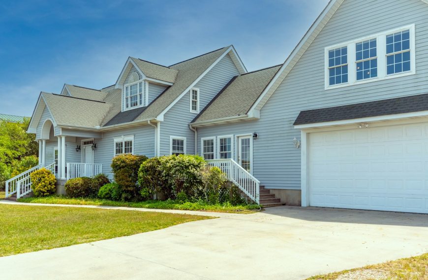 a white house with a large driveway in front of it