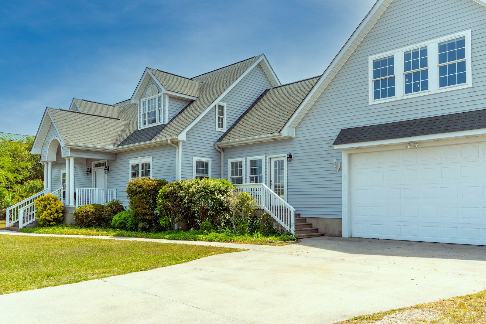 a white house with a large driveway in front of it