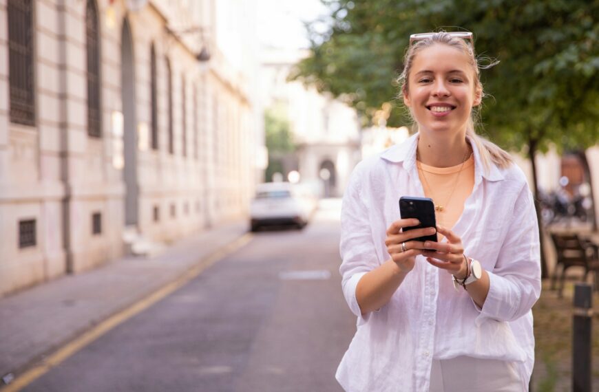 a woman standing on a street holding a cell phone