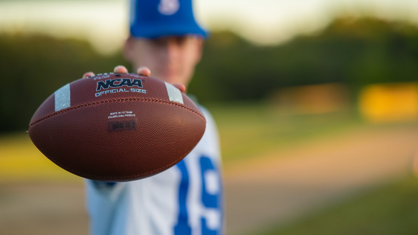 a close up of a person holding a football