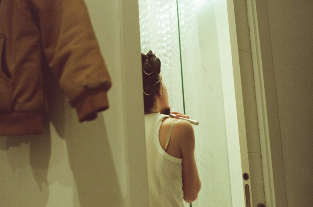 A woman standing in front of a bathroom mirror