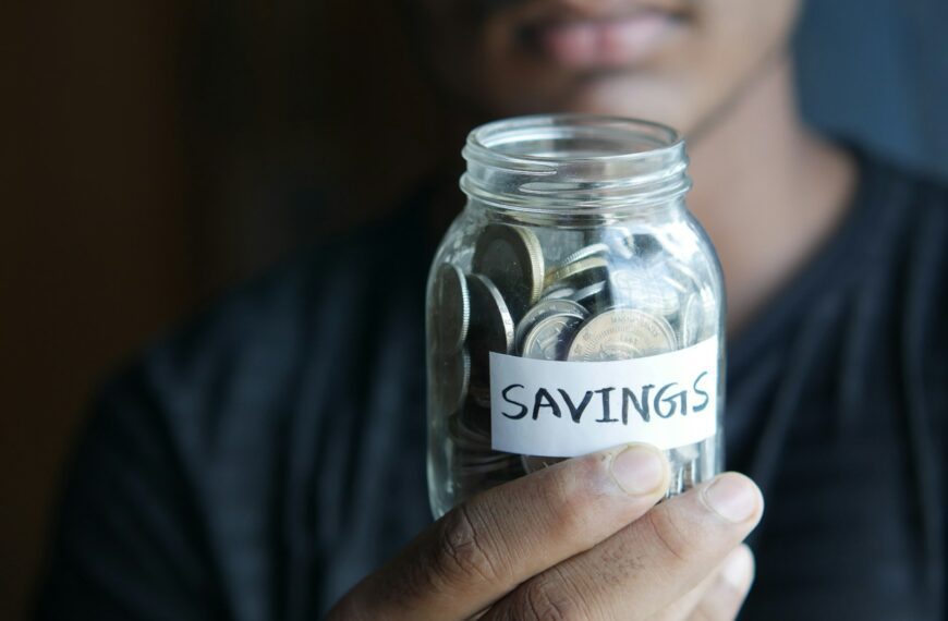 a man holding a jar with a savings label on it