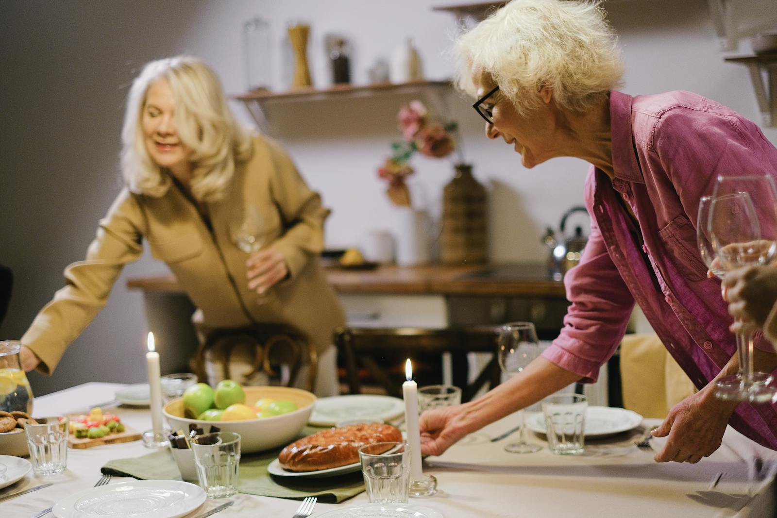 Elderly women setting a dining table for a family dinner, creating a warm and inviting atmosphere at home.