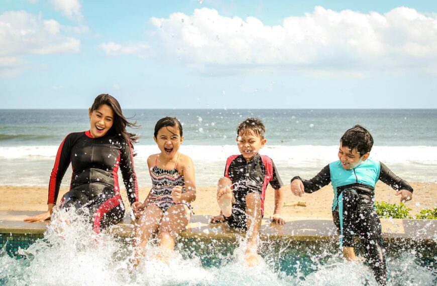 A family having fun splashing water near the seashore on a sunny day in Bali, Indonesia.