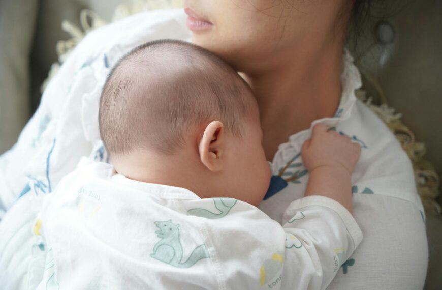 A newborn baby peacefully sleeps on the mother's chest, capturing a tender moment of love and comfort.