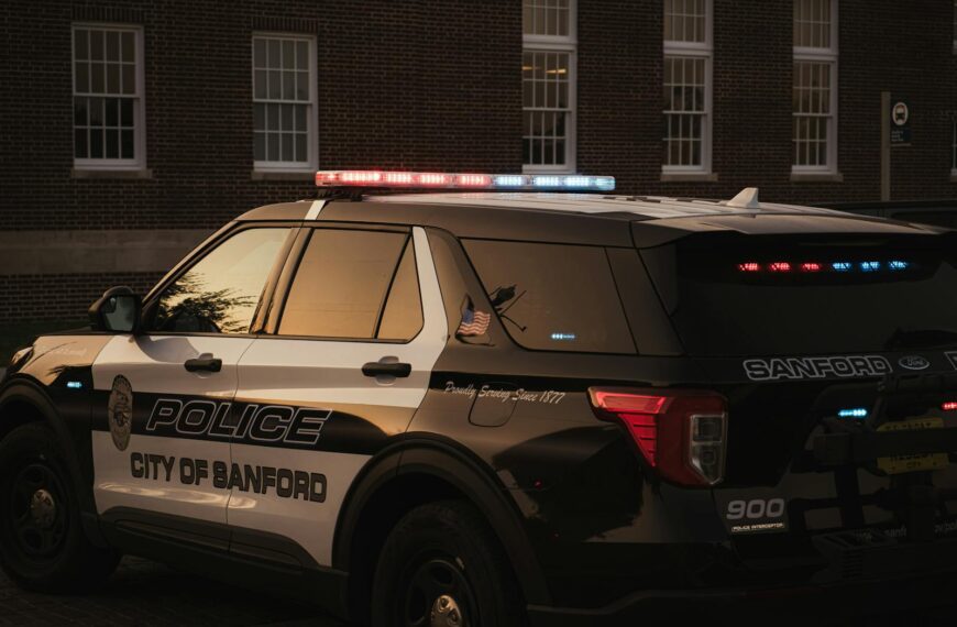 Sanford police vehicle parked outdoors at twilight, showcasing red and blue lights.