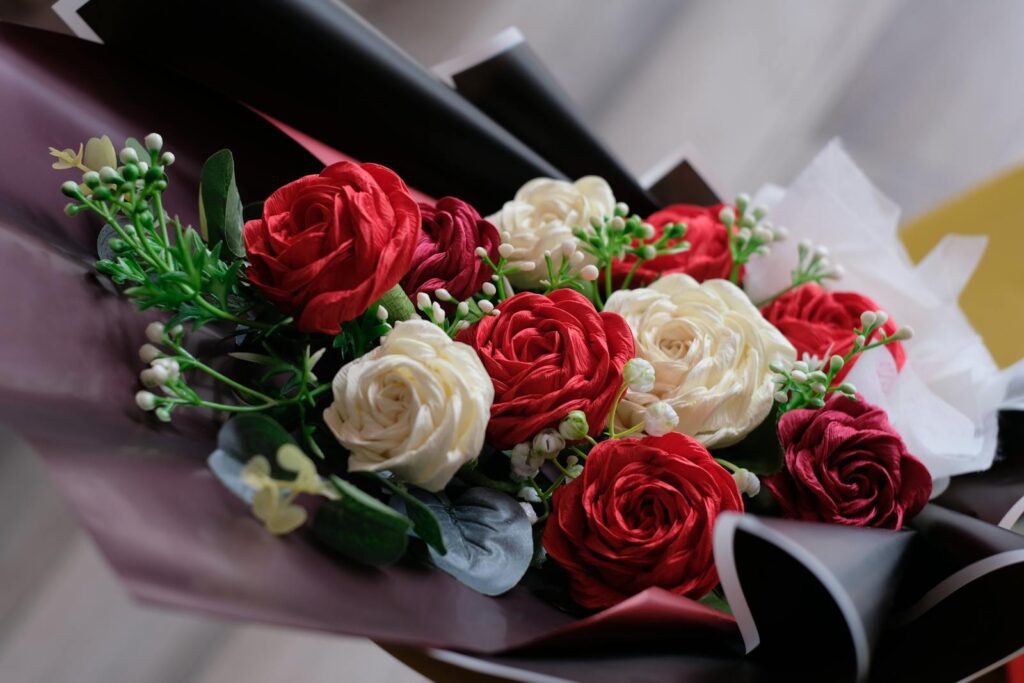 Beautiful close-up of a red and white rose bouquet with greenery.