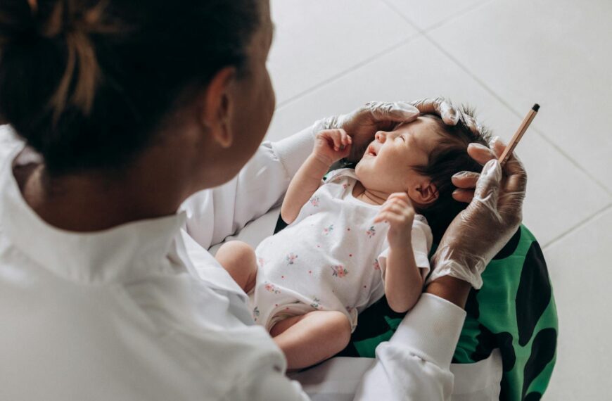 A medical professional examines a newborn baby indoors, highlighting healthcare and care.