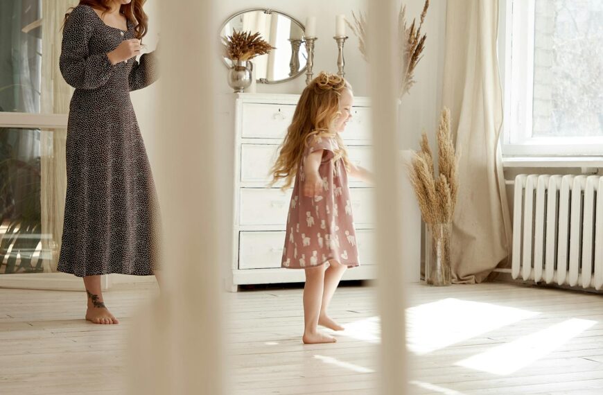 Charming indoor scene of a mother and daughter enjoying a sunny day in a stylish, airy room.
