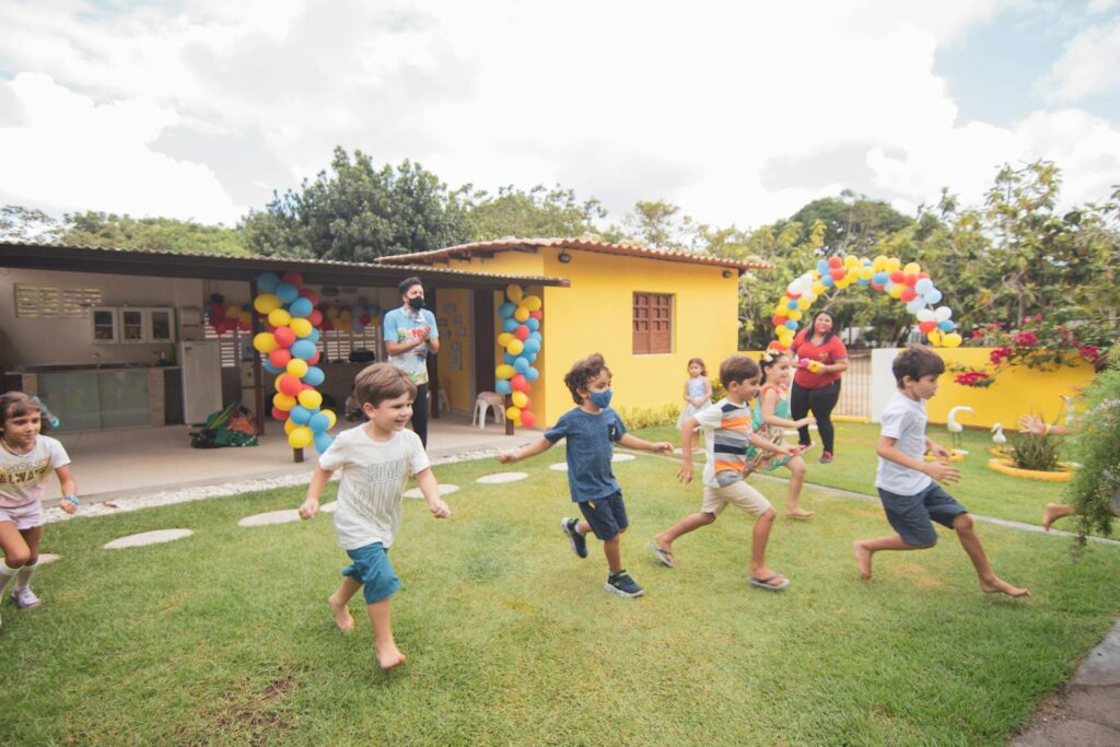 Kids running and playing in a colorful birthday party setting outdoors.