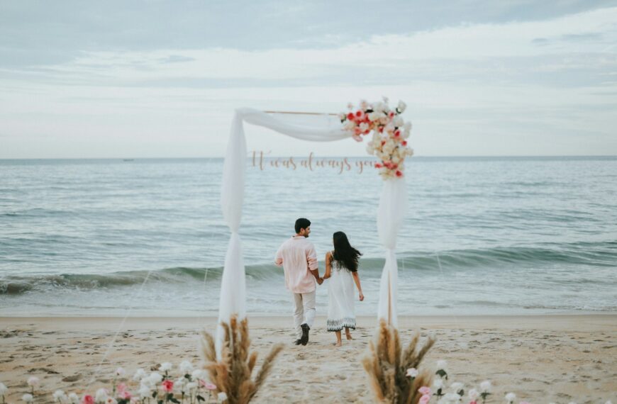 Couple holding hands at beach wedding ceremony