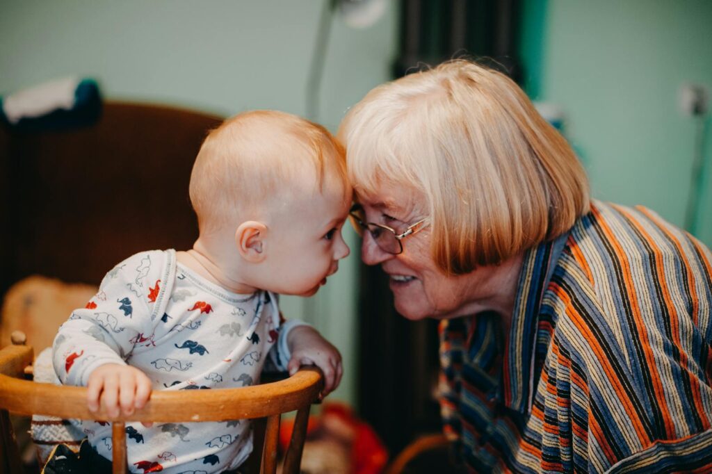 A touching moment shared between a baby and grandmother indoors.